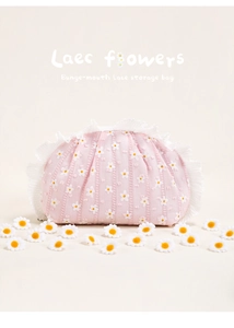 Detail of pink floral makeup bag with daisy patterns and white lace trim edge