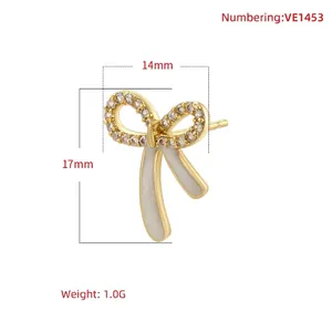 Elegant white enamel bow earrings with sparkling cubic zirconia on a minimalist white backdrop