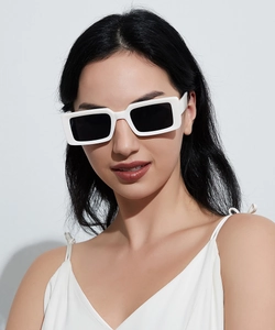Close-up of white rectangular thick-frame sunglasses with dark lenses on a model face