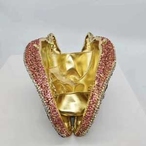 Detail of a heart-shaped gold clutch bag encrusted with pink and silver rhinestones