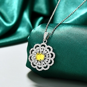 Collier tournesol en argent avec pierre jaune et cristaux sur de la soie verte