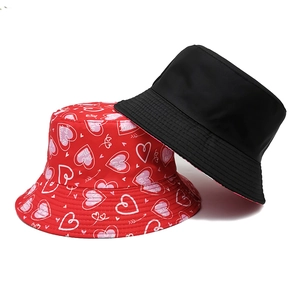 Detail view of red heart print and solid black reversible style sun bucket hats