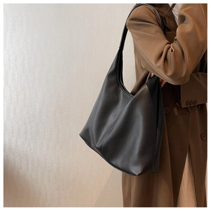 Minimalist black pebble leather tote bag shown on a model for a stylish daily commute