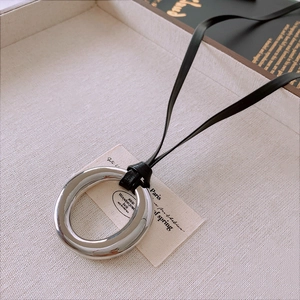 Detail of silver polished large hoop pendant on a black leather cord necklace