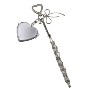 Silver metal handbag charm with heart locket, bow knot, and long chain tassel fringe
