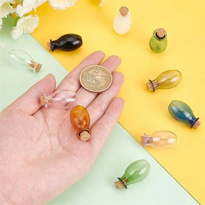Miniature teardrop glass bottles in mixed colors with cork stoppers and coin for scale