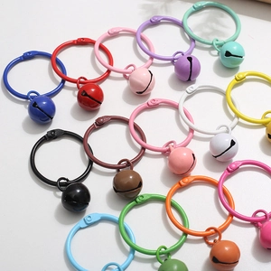 Colorful metal binder rings with matching bells arranged on a white background