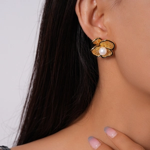 Detailed macro shot of 18k gold-plated flower earrings with pearl and woven texture detail