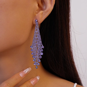 Close-up of model wearing geometric purple rhinestone tassel drop earrings