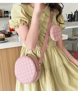 Pink round quilted crossbody bag detail showing small coin purse and strap attachment