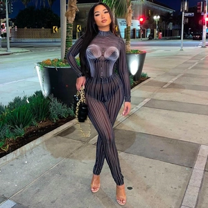 Women's black bodycon jumpsuit with white contour stripes in a stylish urban street setting