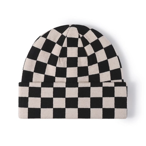 Classic black and white checkered knitted beanie with thick texture and cuffed brim
