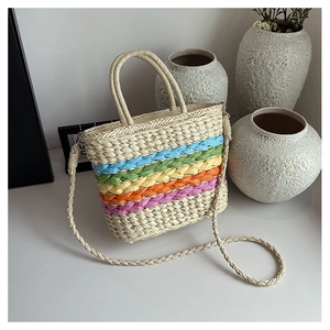 Detail of straw woven handbag with vibrant rainbow stripes and woven handles