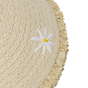 Detail of hand-woven straw hat with delicate white daisy and raffia fringe accents