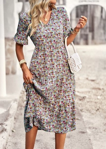 Detail of blue floral V-neck dress featuring ruffled sleeves and multi-layer tiered cake skirt