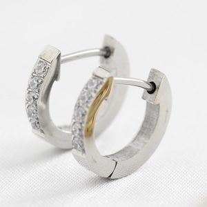 Macro view of silver stainless steel hoop earrings with white zircon stone inlay