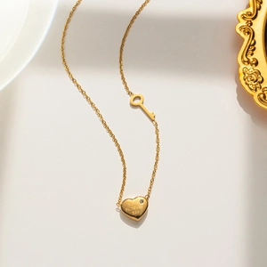 Detail of gold heart and key pendants with Love Forever 520 engraving and small crystal