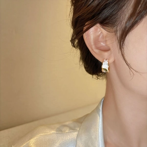 Close-up view of elegant French style zircon pearl earrings worn on a woman's earlobe