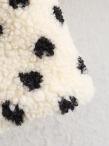 Detailed close-up showing soft black and white polka dot fleece texture on the jacket