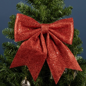 Grand nœud rouge scintillant suspendu au sapin de Noël pour décoration festive