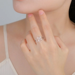 Intertwined stainless steel rings in Celtic knot style shown on a hand model