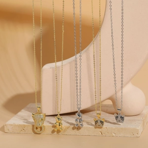 Detail of elegant gold and silver animal pendants with zircon stones on stone base