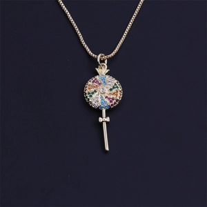 Macro shot of gold lollipop pendant with colorful crystals and delicate bow detail