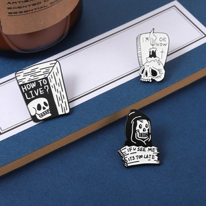 Detailed view of three black and white skull enamel pins with Gothic English slogans