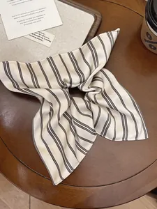 Detailed view of striped satin scrunchie with silky texture on a wooden table
