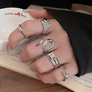 Detail shot of silver geometric lava texture and Mobius rings worn by model on multiple fingers
