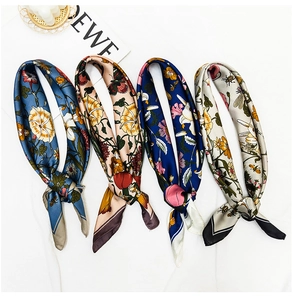 Detailed macro view of four printed silk scarves featuring floral and nature motifs