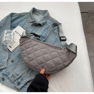 Detailed top view of a grey quilted nylon crescent crossbody bag with adjustable strap