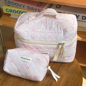 Pink quilted makeup bag set with ribbon bows and handles for travel and daily use