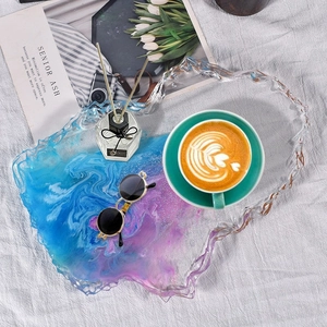 Close-up of irregular blue resin coaster tray with marble texture on fabric background