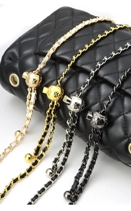 Detail view of woven leather and metal chain straps with adjustable gold ball sliders