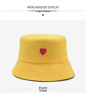 Detail of red heart embroidery on yellow sun bucket hat with premium twill texture