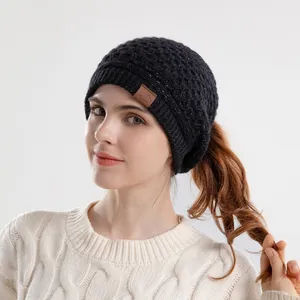 Women's black knit beanie with ear protection, ponytail hole and silver glitter accents