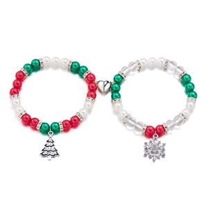 Detail of Christmas magnetic couple bracelets with festive beads, tree and snowflake charms