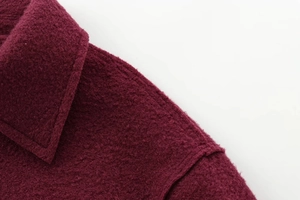Détail macro du col d'une veste bordeaux en laine avec texture de tissu de haute qualité