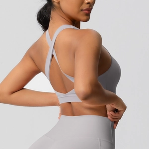 Detail van lichtgrijze sportbeha met gekruiste rug en yoga legging met hoge taille