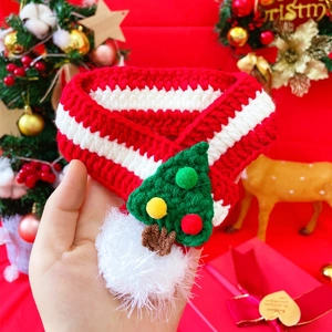 Detail of red and white striped knit pet scarf with a green Christmas tree and pom-pom