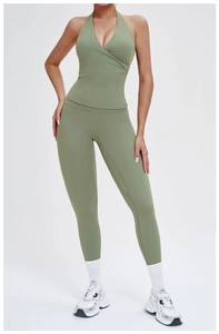 Detail of high-waisted yoga pants and cross-neck sports bra in sage green set