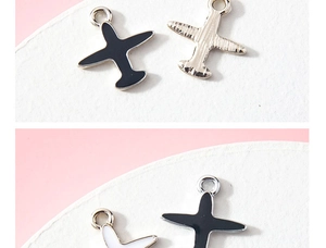 Close-up of enamel airplane pendants in black, white and silver for DIY jewelry