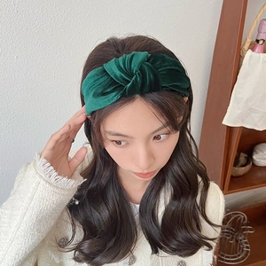 Deep forest green velvet knotted headband worn by a model for a stylish look