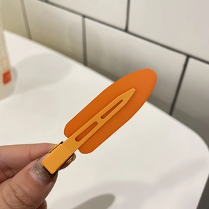 Detailed macro shot of an orange jelly hair clip with a stylish hollowed-out line design