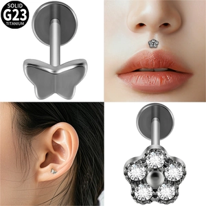 Vue macro de piercings labret en titane G23 avec motifs papillon et fleurs en zircone
