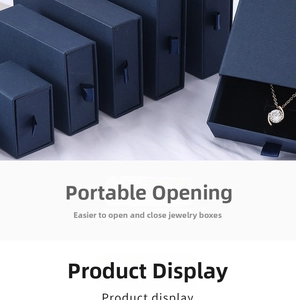 Detail of dark blue drawer jewelry box with satin ribbon handle and gold necklace