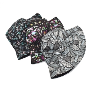 Detail showing three different bucket hats with tropical palm and abstract prints