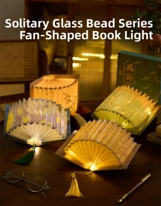 Macro detail of LED fan-shaped book lamp with classic art prints and silk tassels