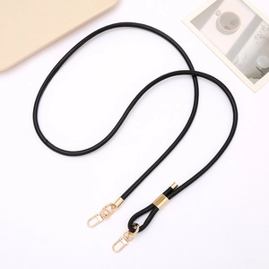 Detail of adjustable black PU leather crossbody strap with gold metal buckles for bags